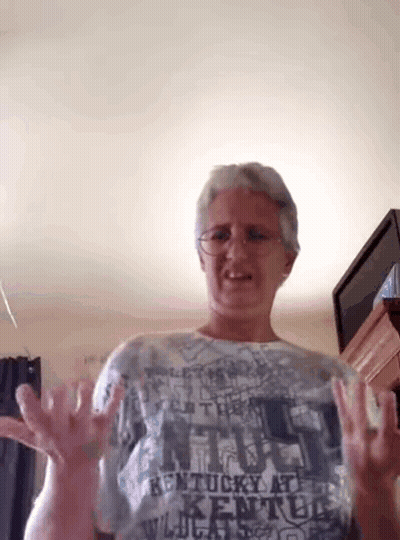 A Woman Wearing A Kentucky At Kentucky Shirt Is Making A Funny Face GIF