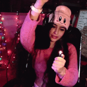 A Woman Wearing A Kirby Hat Is Holding A Lighter In Her Hand GIF