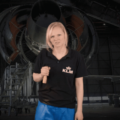 A Woman Wearing A Klm Shirt Is Holding A Flashlight GIF