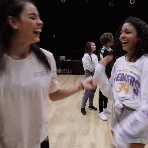 A Woman Wearing A Lakers Jersey Laughs With Another Woman GIF