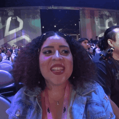 A Woman Wearing A Lanyard That Says ' I Love You ' On It Smiles GIF