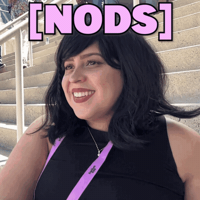 A Woman Wearing A Lanyard That Says Victoria 'S Secret Smiles In Front Of Stairs GIF