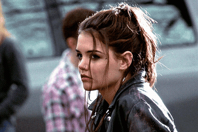 A Woman Wearing A Leather Jacket And A Ponytail GIF