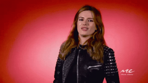 A Woman Wearing A Leather Jacket With Studs On The Sleeves GIF