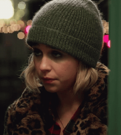 A Woman Wearing A Leopard Print Coat And A Green Beanie GIF