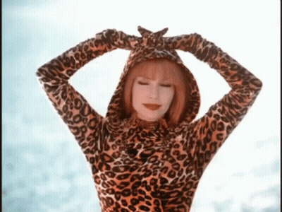 A Woman Wearing A Leopard Print Hooded Top With Her Hands On Her Head GIF
