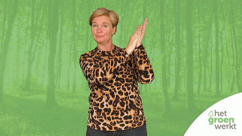 A Woman Wearing A Leopard Print Shirt Stands In Front Of A Green Background With Het Groen Werkt Written On It GIF