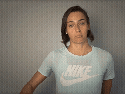 A Woman Wearing A Light Blue Nike Shirt Makes A Funny Face GIF