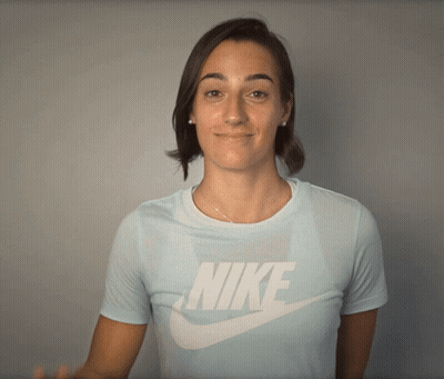 A Woman Wearing A Light Blue Nike Shirt Smiles GIF