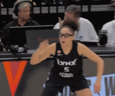 A Woman Wearing A Lynx 5 Jersey Stands On A Bench GIF