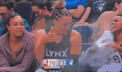 A Woman Wearing A Lynx Shirt Is Sitting In The Stands During A Basketball Game GIF