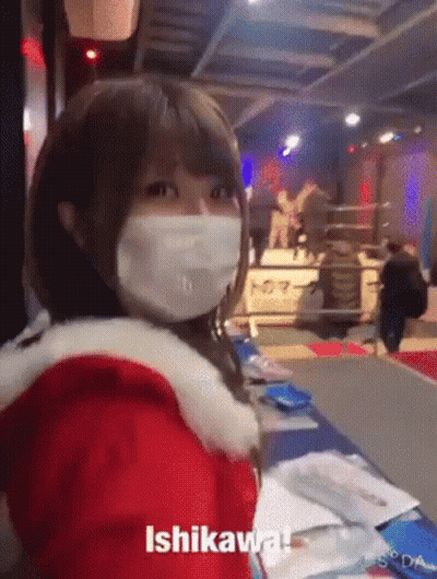 A Woman Wearing A Mask And A Santa Claus Outfit Is Standing In A Room . GIF