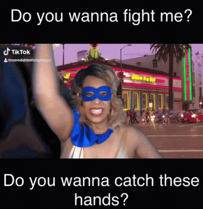 A Woman Wearing A Mask And A Superhero Costume Says Do You Wanna Fight Me Do You Wanna Catch These Hands GIF