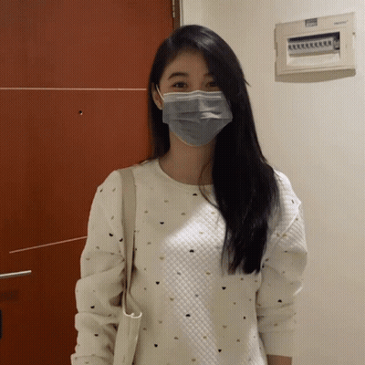 A Woman Wearing A Mask And A White Sweater GIF