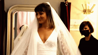 A Woman Wearing A Mask Is Standing Next To A Woman Wearing A Veil GIF