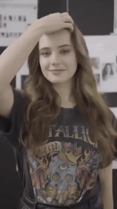 A Woman Wearing A Metallica T-Shirt Holds Her Hand To Her Head GIF