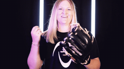 A Woman Wearing A Mizuno Glove Holds Her Fist Up GIF
