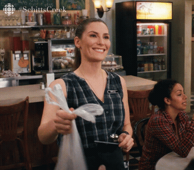 A Woman Wearing A Name Tag That Says Amy Smiles GIF