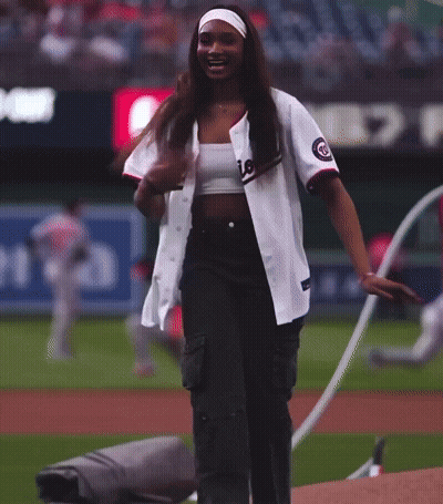 A Woman Wearing A Nationals Jersey Stands On The Field GIF