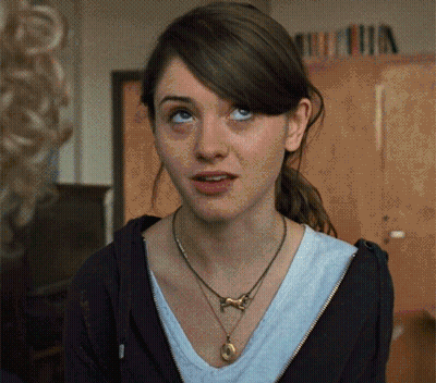 A Woman Wearing A Necklace And A Black Hoodie Looks Up GIF