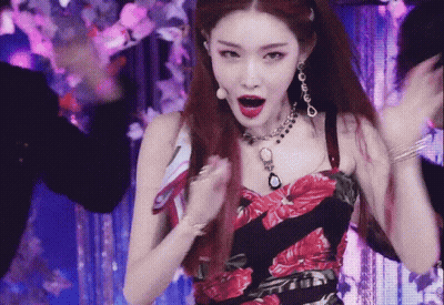 A Woman Wearing A Necklace And Earrings Is Dancing GIF