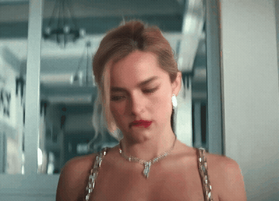 A Woman Wearing A Necklace And Earrings Is Looking Down GIF