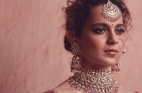 A Woman Wearing A Necklace And Earrings With A Maang Tikka On Her Head GIF