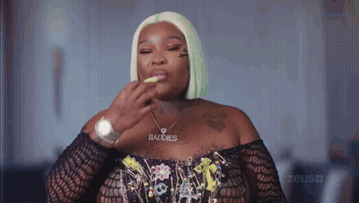 A Woman Wearing A Necklace That Says Baddies GIF