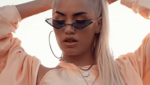 A Woman Wearing A Necklace That Says Puma On It GIF