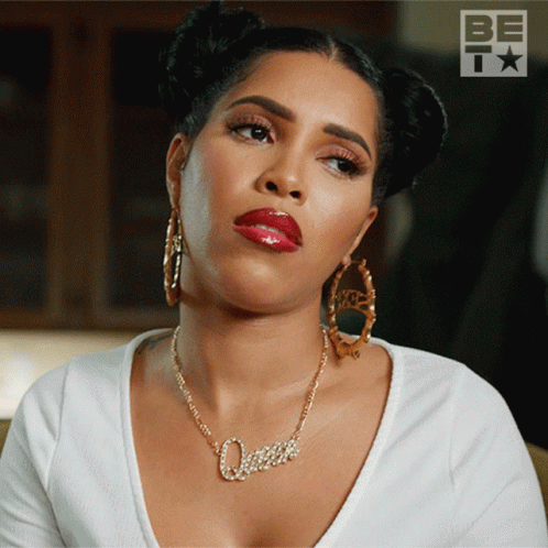 A Woman Wearing A Necklace That Says Queen GIF