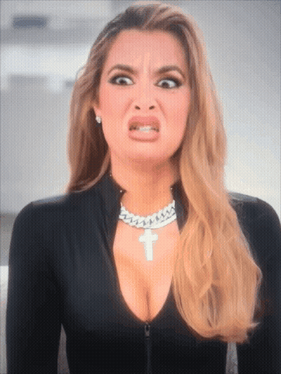 A Woman Wearing A Necklace With A Cross On It GIF