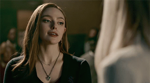 A Woman Wearing A Necklace With A Heart Shaped Pendant GIF