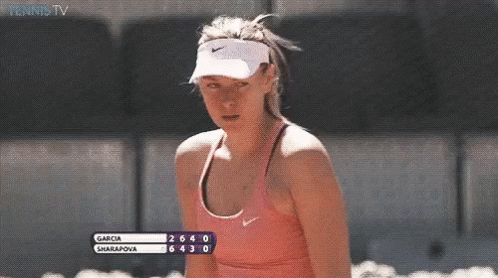 A Woman Wearing A Nike Visor And A Pink Tank Top Is Watching A Tennis Match Between Garcia And Sharapova GIF