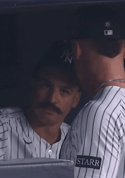 A Woman Wearing A Ny Hat Looks At Something In The Distance GIF