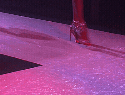 A Woman Wearing A Pair Of High Heels Walking Down A Runway GIF