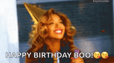 A Woman Wearing A Party Hat Is Smiling And Holding A Lollipop . GIF