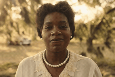 A Woman Wearing A Pearl Necklace And Pearl Earrings GIF