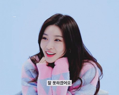 A Woman Wearing A Pink And Blue Striped Sweater Has A Sticker On Her Sweater That Says " 잘 못 하네요 " GIF