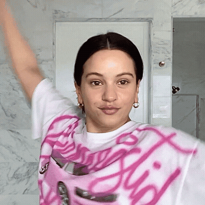 A Woman Wearing A Pink And White Shirt That Says ' Barbie ' GIF