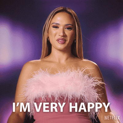 A Woman Wearing A Pink Feathered Top Says I 'M Very Happy GIF
