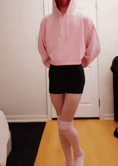 A Woman Wearing A Pink Hoodie And Black Shorts GIF