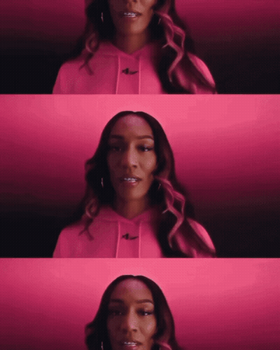 A Woman Wearing A Pink Hoodie With The Nike Logo On The Front GIF