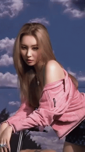 A Woman Wearing A Pink Jacket With The Word Supreme On The Sleeve GIF