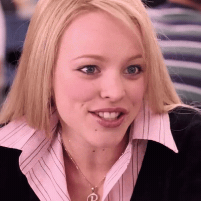 A Woman Wearing A Pink Shirt And A Necklace With The Letter P On It GIF