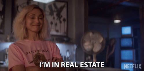 A Woman Wearing A Pink Shirt That Says I 'M In Real Estate On It GIF