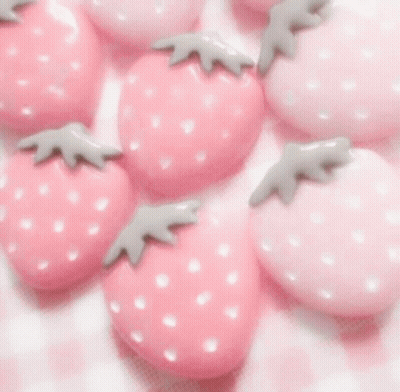 A Woman Wearing A Pink Sweater And A Butterfly Necklace GIF