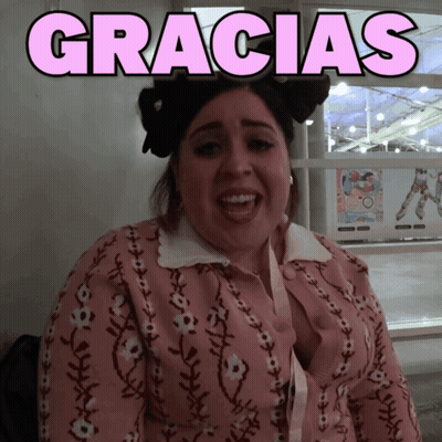 A Woman Wearing A Pink Sweater With The Word Gracias Above Her GIF