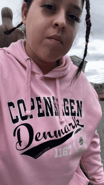 A Woman Wearing A Pink Sweatshirt That Says Copenhagen Denmark GIF