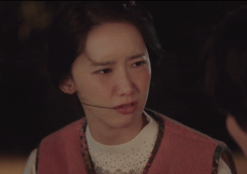 A Woman Wearing A Pink Vest And A Headset Looks At The Camera GIF