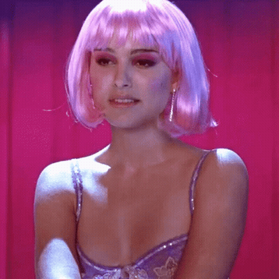 A Woman Wearing A Pink Wig And A Purple Bra With The Word Heaven On Her Chest GIF